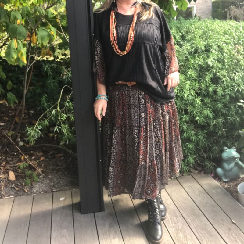 Black boho tunic with beaded necklaces and patterned skirt